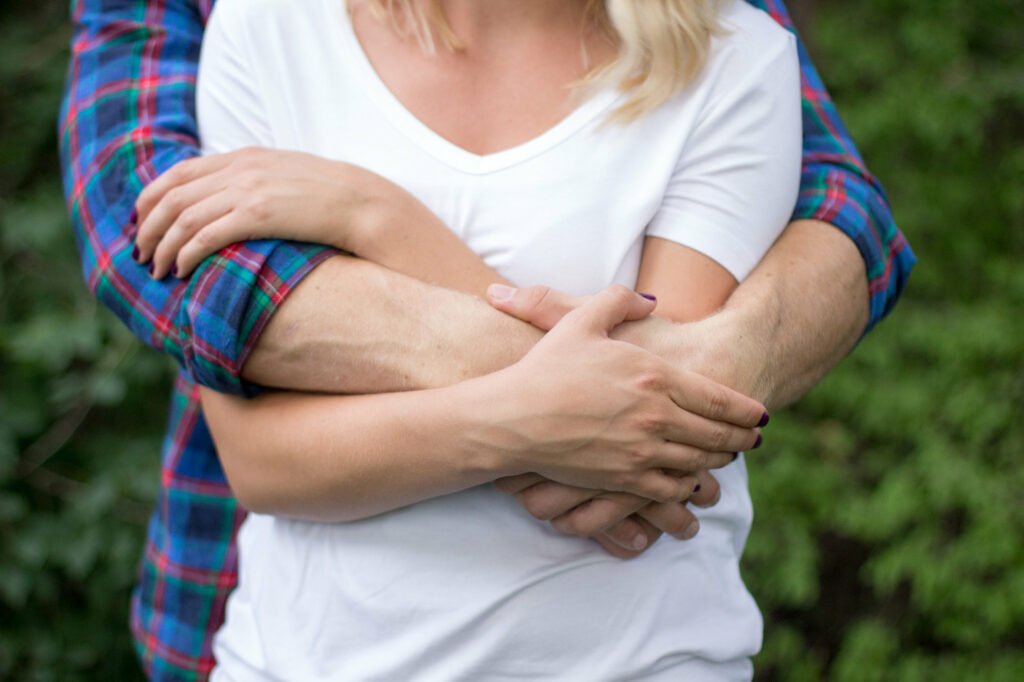 man with arms around woman embracing lovingly