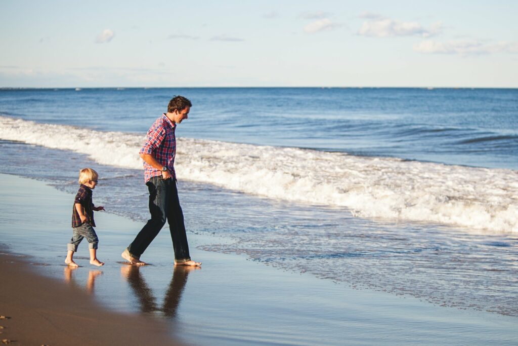 man and child near waves in ocean